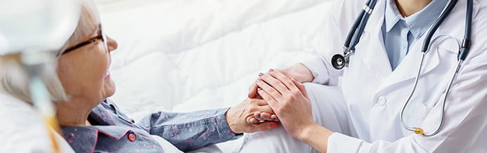 Doctor holds blood cancer patients hand