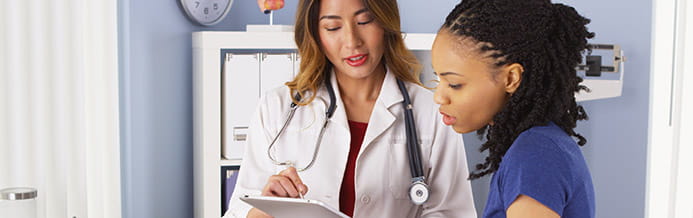Female gynecological oncologist reviews vulvar cancer information with patient