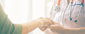 Nurse and patient hold hands