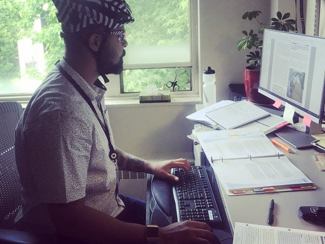 Wright wearing helmet at his desk