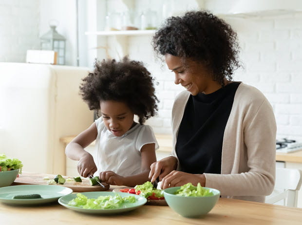 Mother and daughter making salad