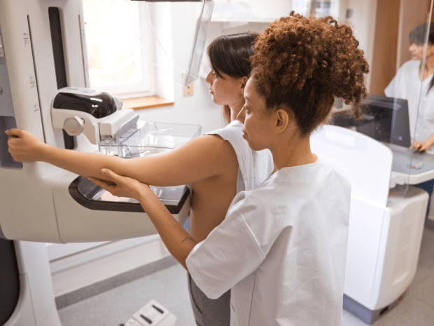 Photo of individual at a mammography machine along with a provider