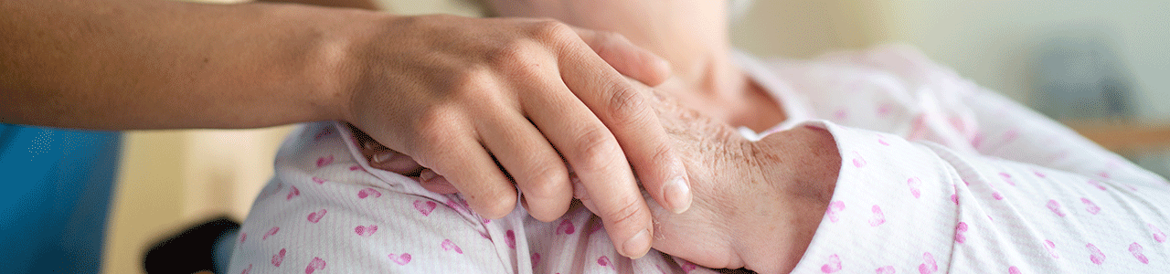 Hospice volunteer holding hospice patient hand