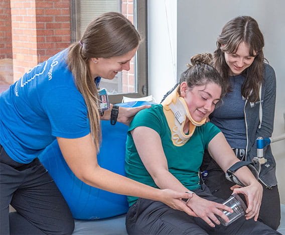 Two Legacy RIO staff members assisting a RIO patient