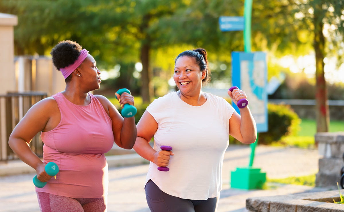 two women exercising together in a park