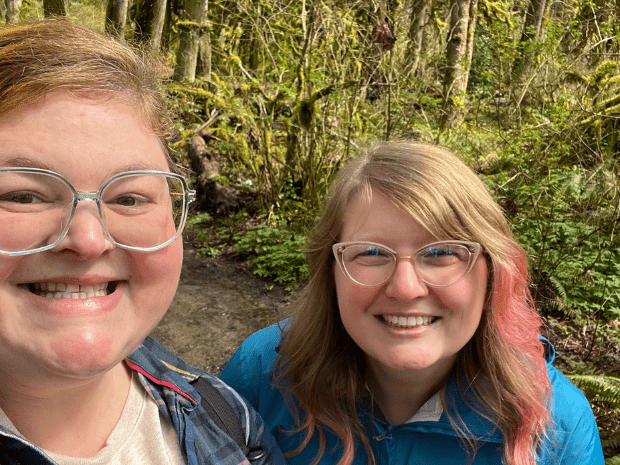 Heather Webster smiling outside, posing alongside a friend or partner